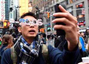 Revelers take selfies as they gather in Times Square  waiting for the ball to drop on December 31, 2015 in New York. Organizers expect around one million revelers to attend the New Year's celebration in Times Square. AFP PHOTO/DON EMMERTDON EMMERT/AFP/Getty Images